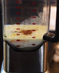 Milk, eggs, sugar and nutmeg in the bowl of a blender.