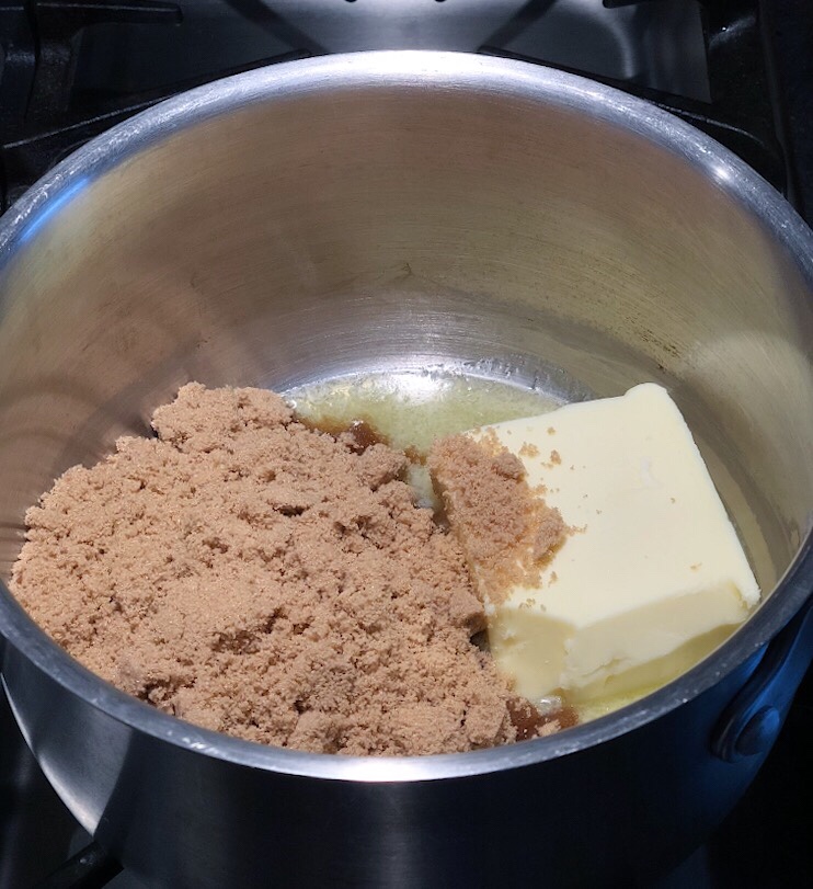 One cup of butter is melting with brown sugar in a stainless steel pot.