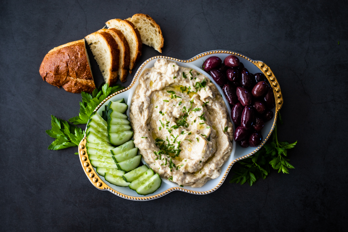 Mutabal recipe on mezze platter with olives, cucumber and bread