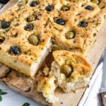 Focaccia bread with olives scattered over.