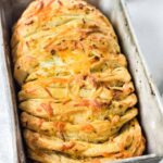 Bread pan with cheesy garlic pull apart bread baked in it.