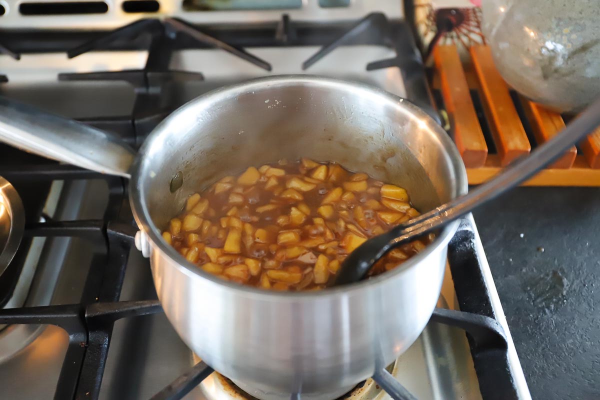 The apple pie filling is brown in the saucepan and ready to cool before using.