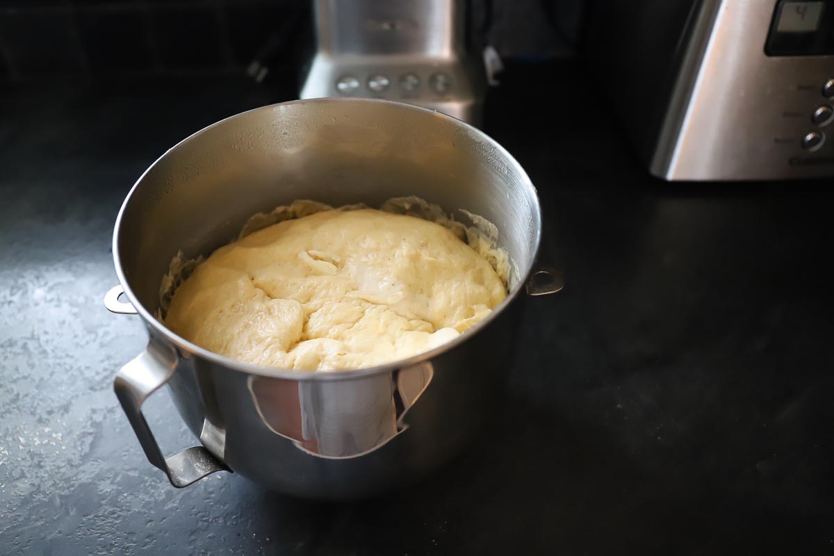 Dough in silver bowl has risen and is now ready to use for cinnamon rolls.