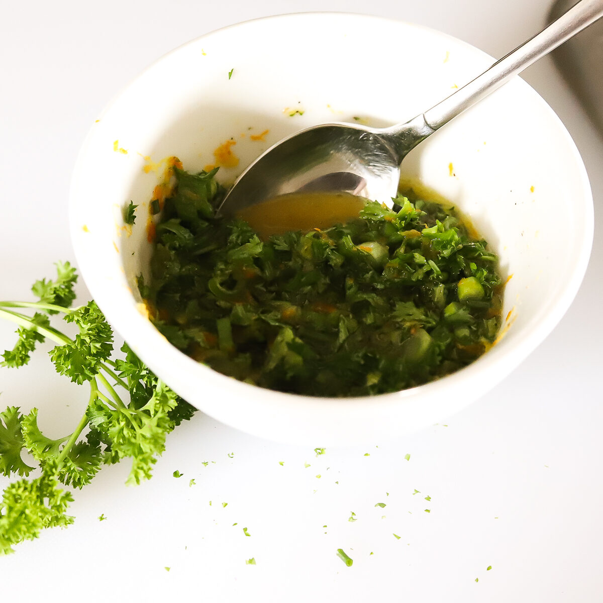 Citrus parsley dressing in white bowl. It looks green.