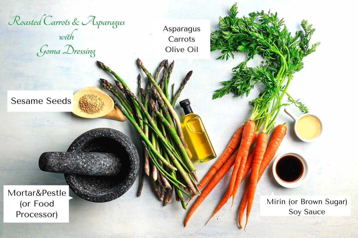A flat lay of the ingredients for this recipe including sesame seeds, asparagus, carrots, olive oil, mirin, soy sauce and a black mortar and pestle.