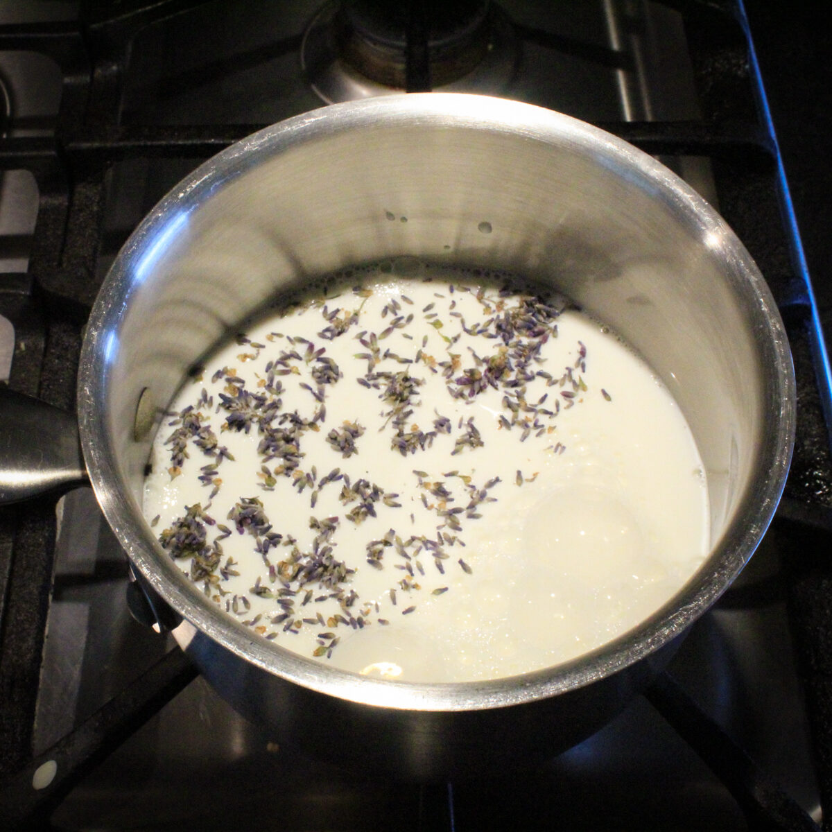 Milk in a pot with lavender buds floating in it.