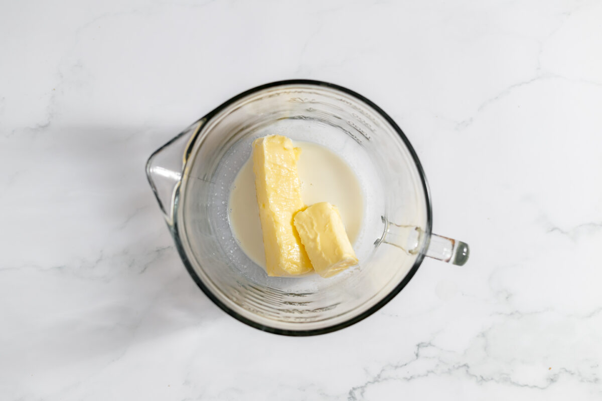 Milk and butter in the bottom of a large glass measuring cup.