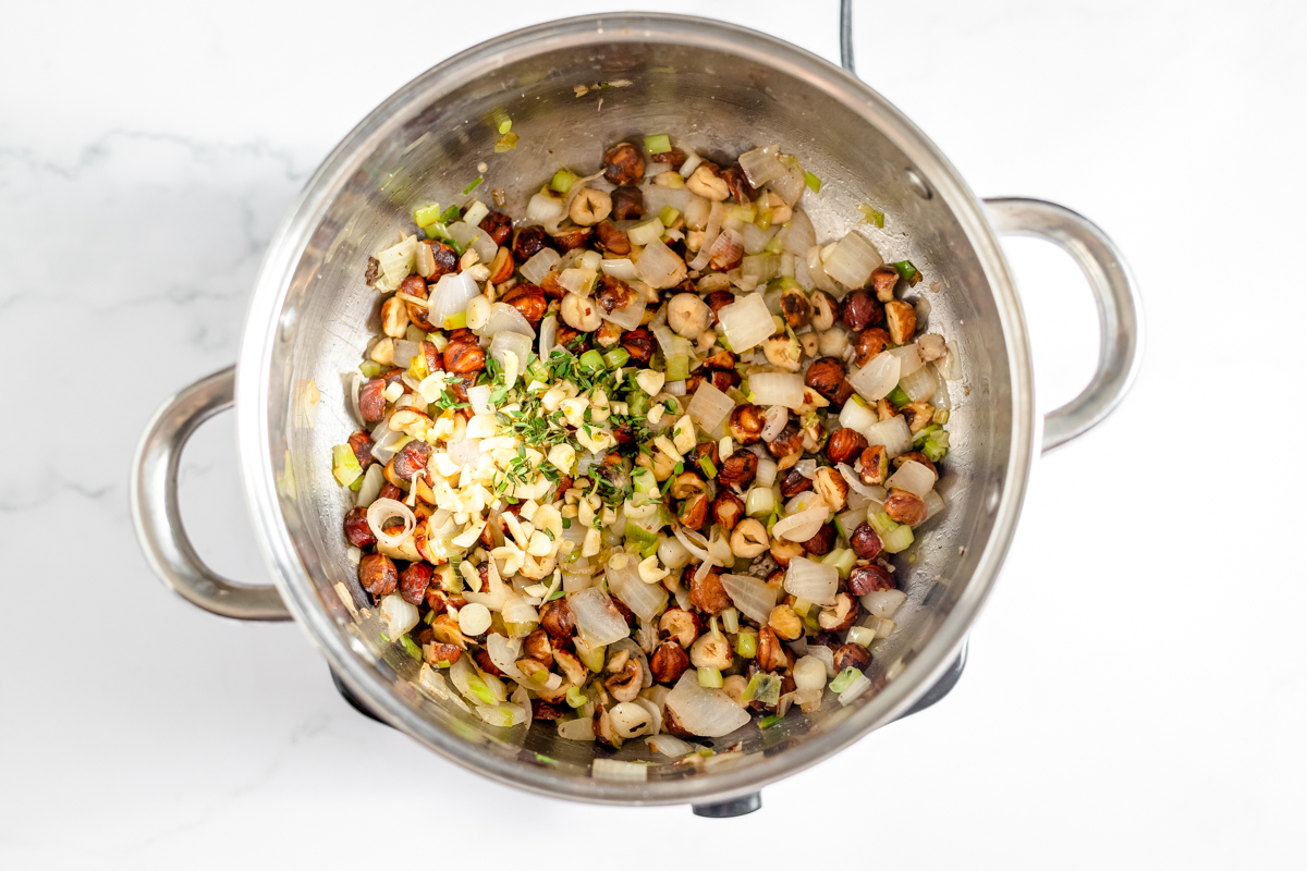 Chopped thyme is added on top of nuts and veggies.