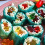 Green fruit rollup wrapped rice krispies with gummy bears in the middle made to look like a sliced sushi roll.