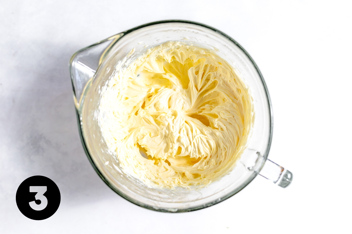 Fluffy, cream colored butter and sugar mixture in the large pyrex mixing cup.