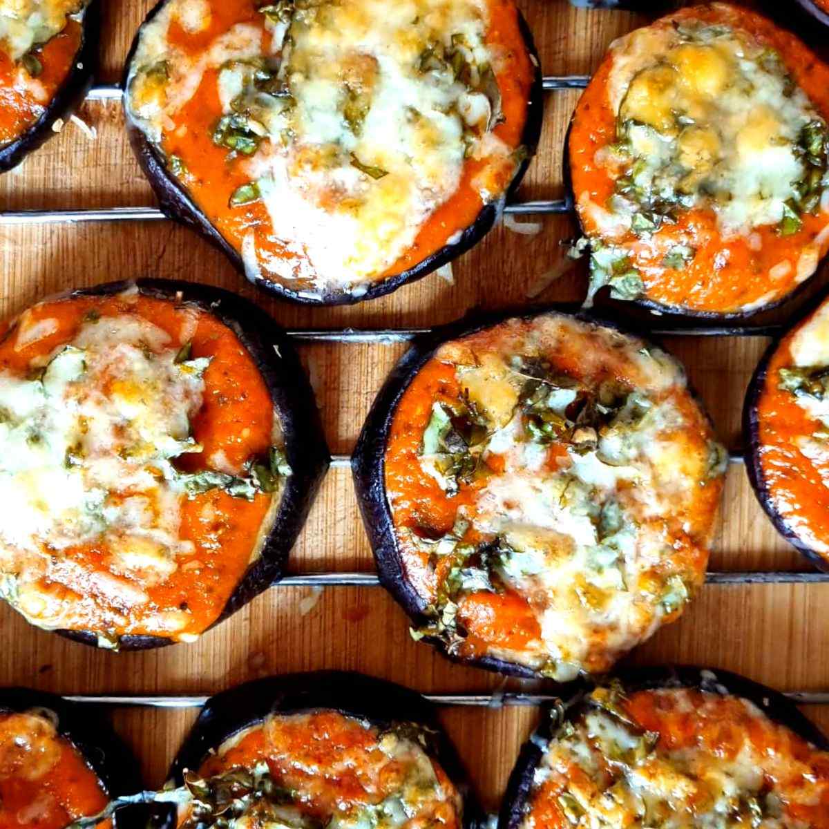 Mini eggplant pizzas made with sliced eggplant as the base and topped with passata sauce and shredded mozzarella cheese.
