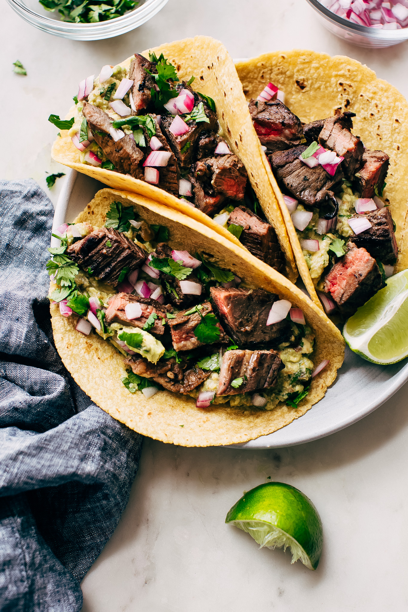 Three soft tacos filled with beef slices and bright salsa.
