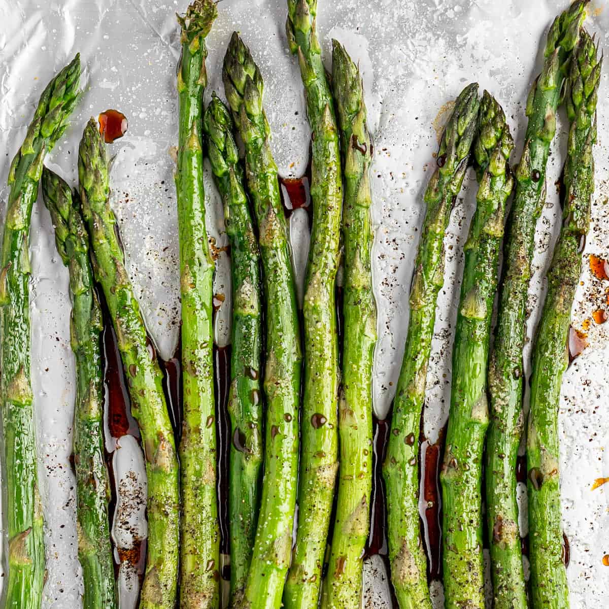 Gren grilled asparagus with balsamic vinegar drops over it.