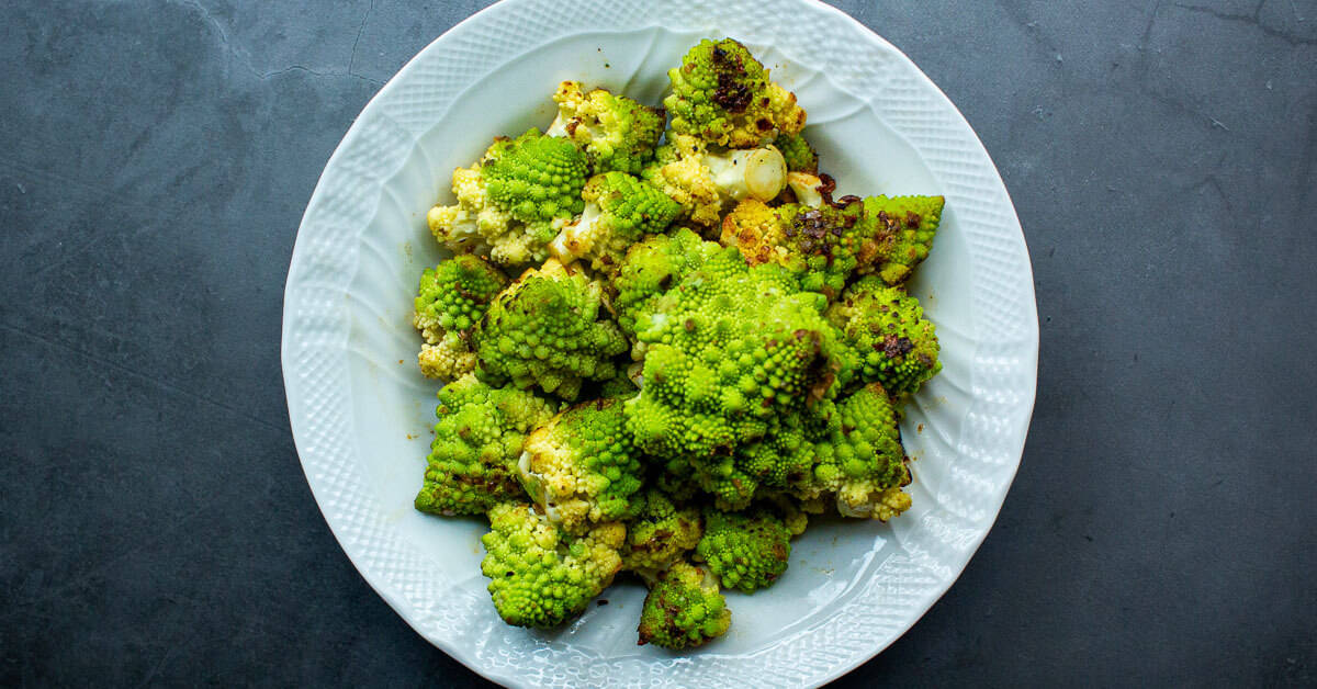 Bright green, whole roasted Romanesco that's been sprinkled with herbs and nuts.