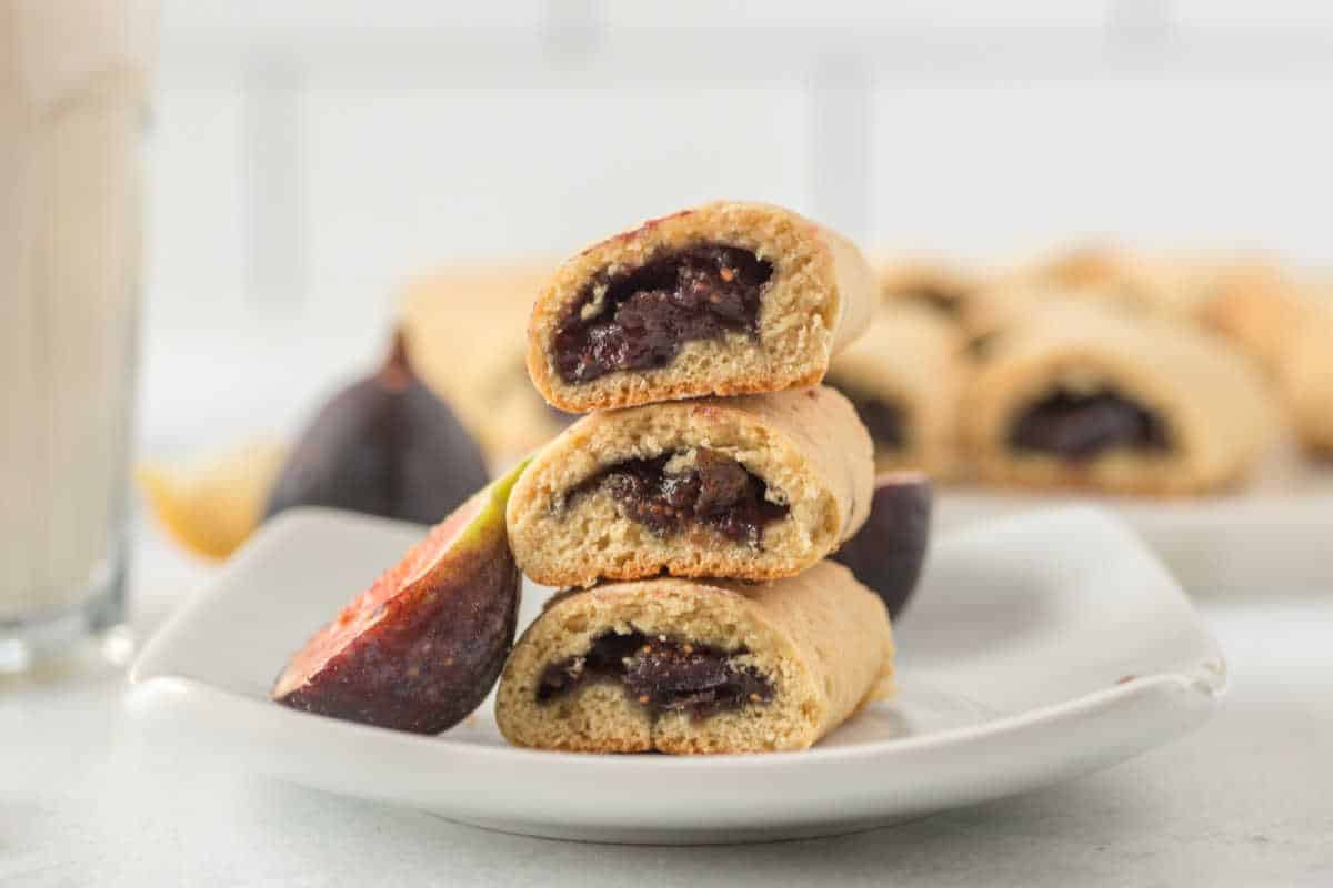 3 fig stuffed cookies stacked on top of each other on a white plate.