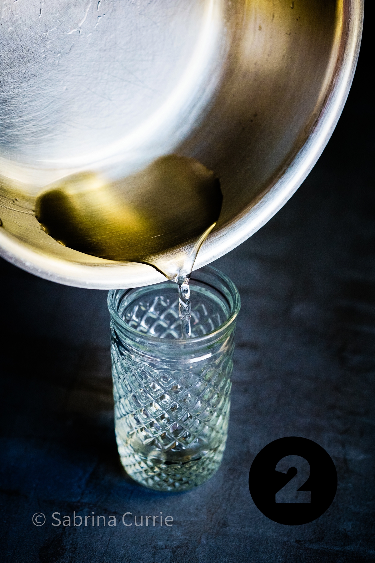 Step 2: Pouring simple syrup into a small mason jar. 