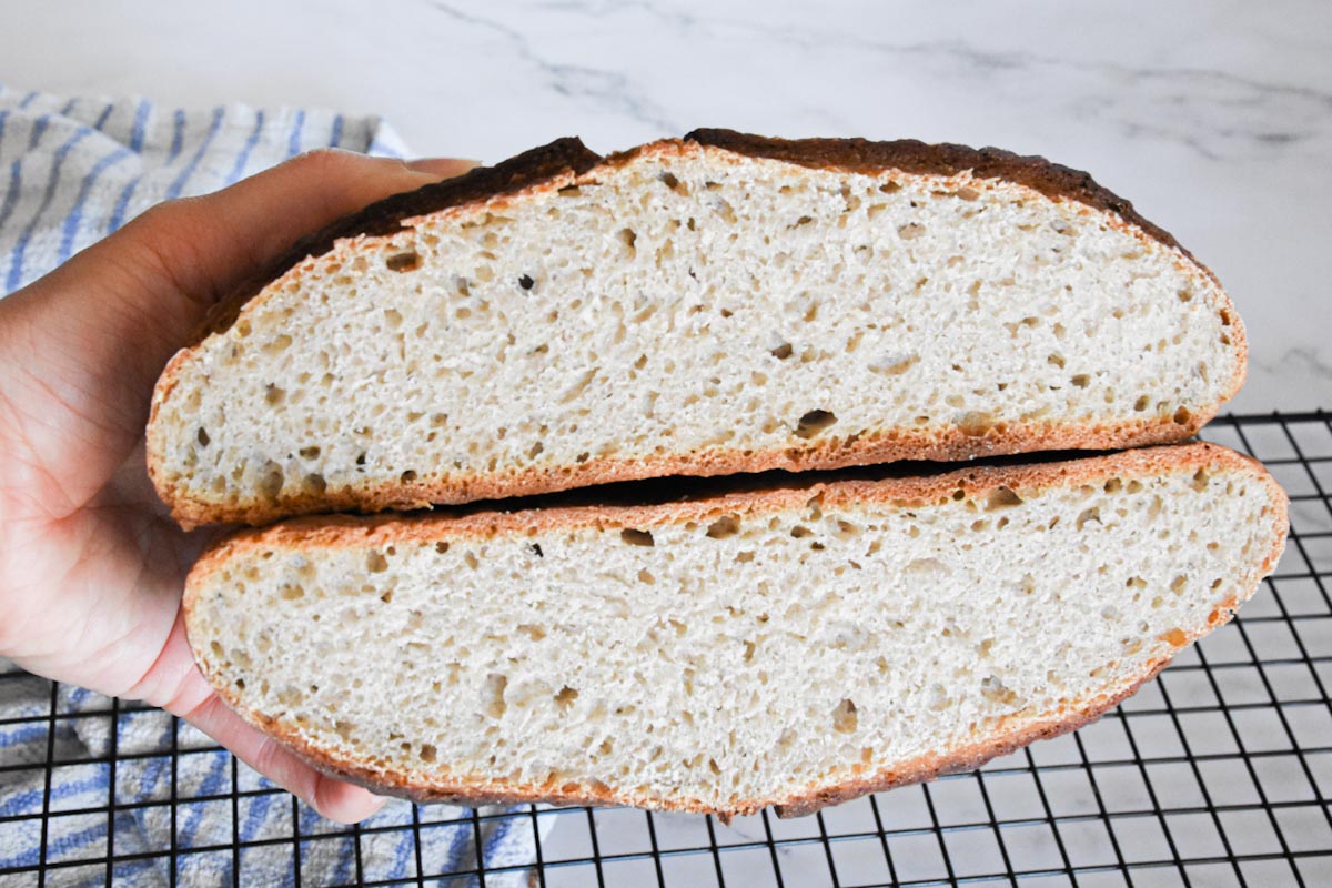 Test loaf of buckwheat bread cut in half and stacked to show the inside of the bread. It is more dense and the loaf is flatter than the finished recipe's loaf.