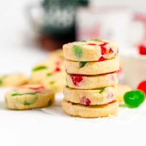 Stack of 5 pale, cream colored cookies studded with green and red candied fruit.