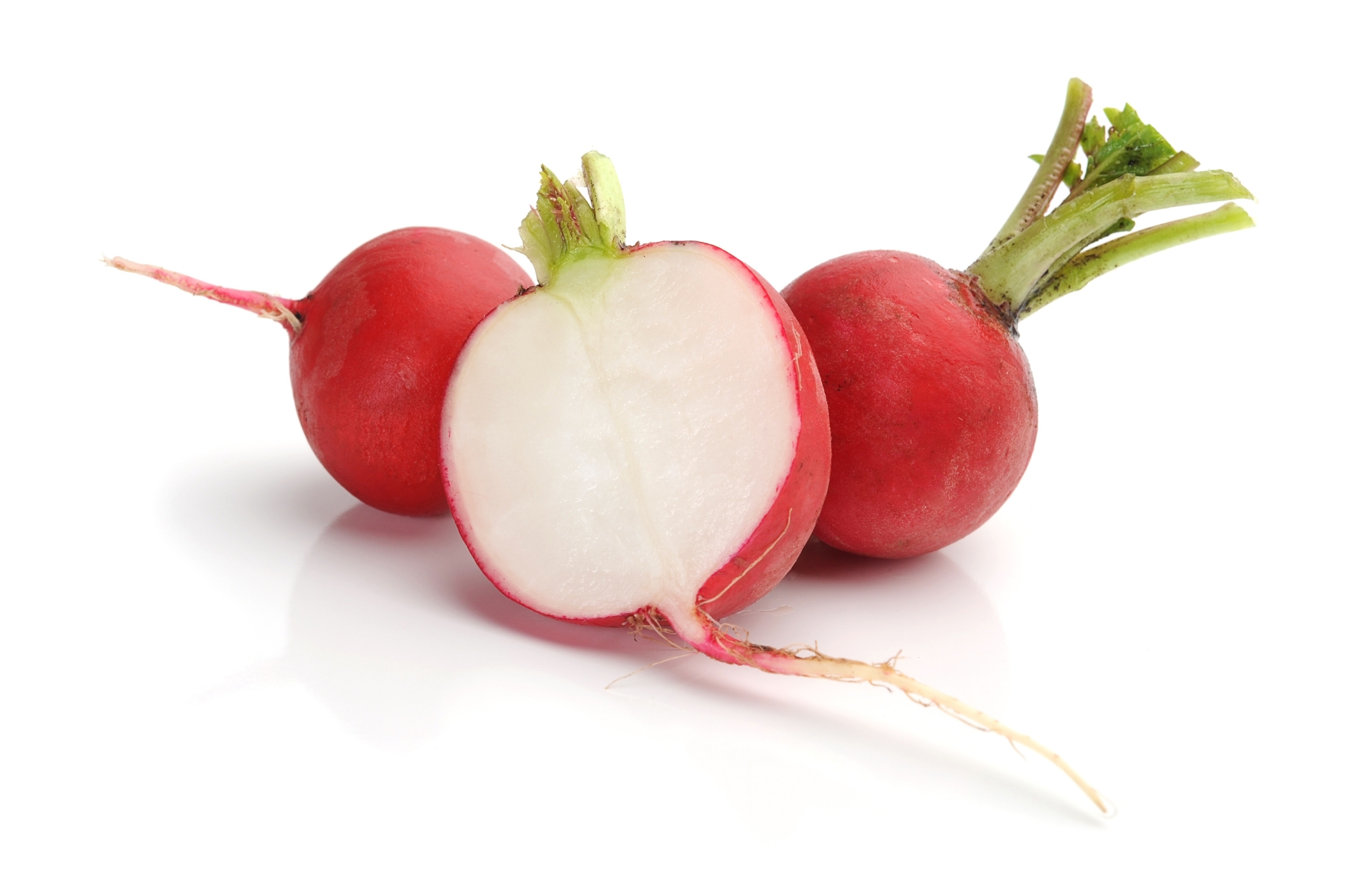 Bright red radishes with center one cut in half to expose the crisp white interior.