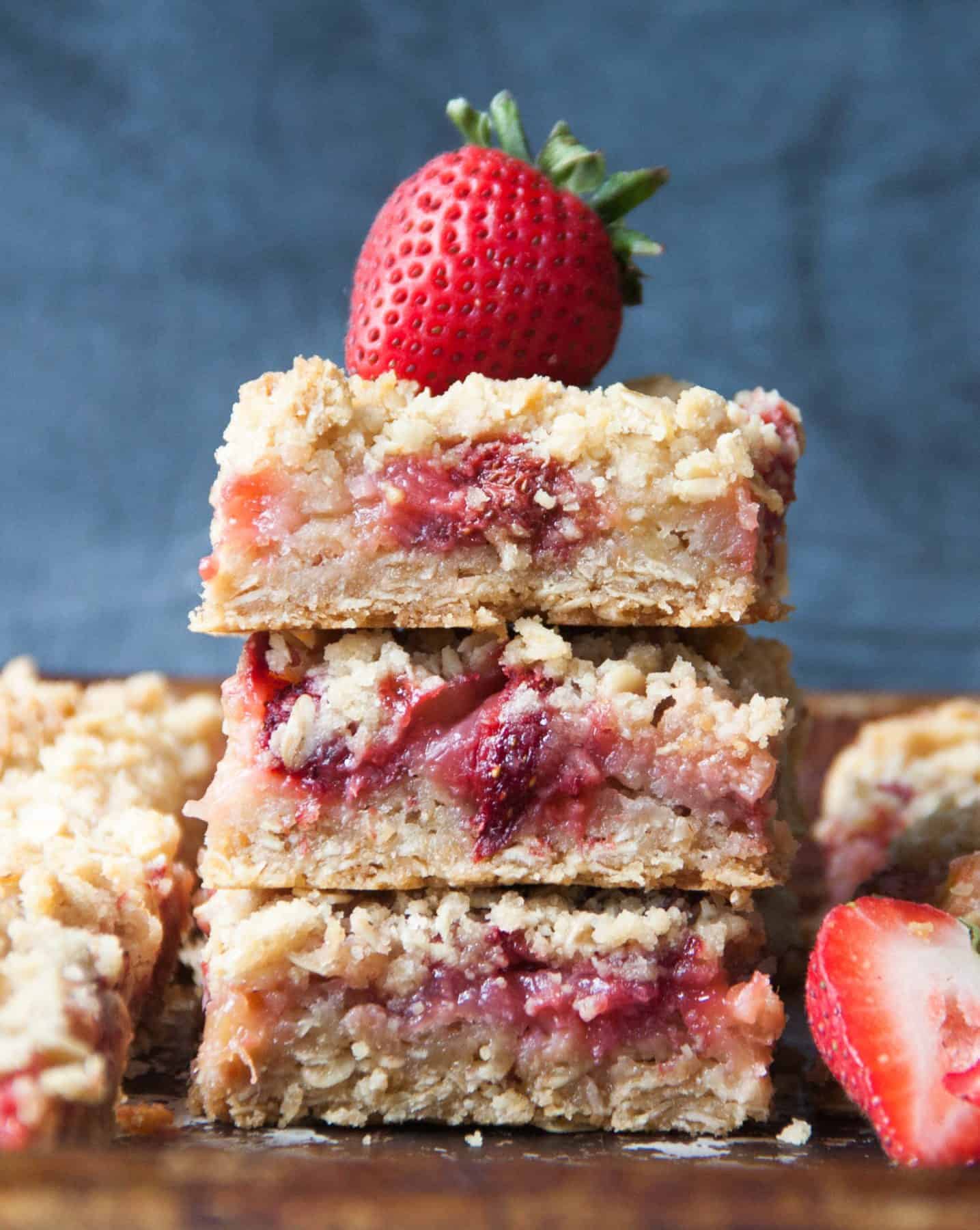 3 pink and brown bars stacked in a small tower and topped with one fresh strawberry.