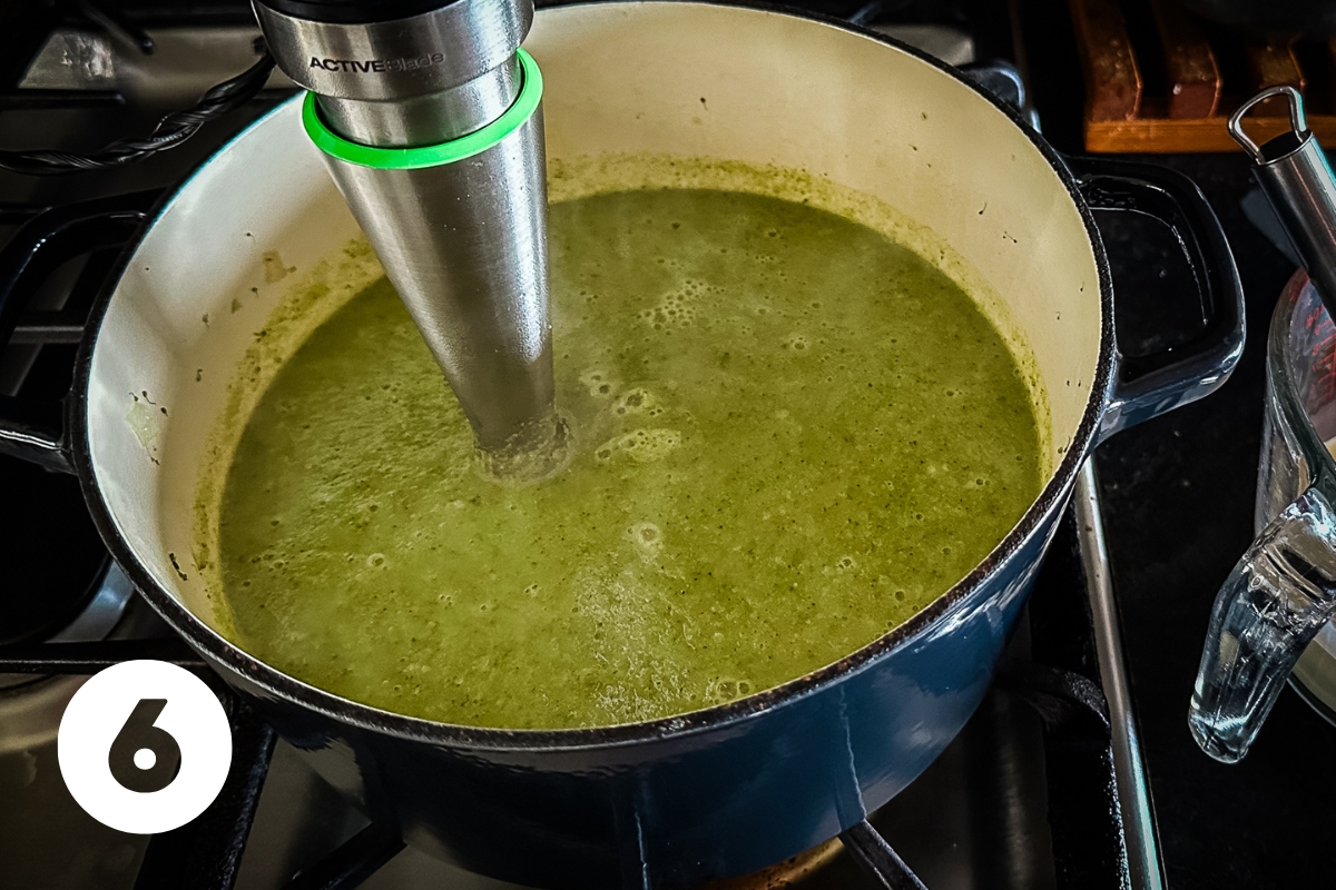 Immersion blender is in the soup and it is fully pureed and creamy green looking.