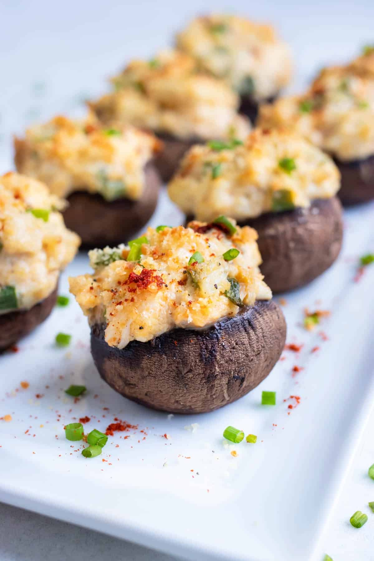 Stuffed mushrooms with a golden melty top and snipped chives sprinkled over.