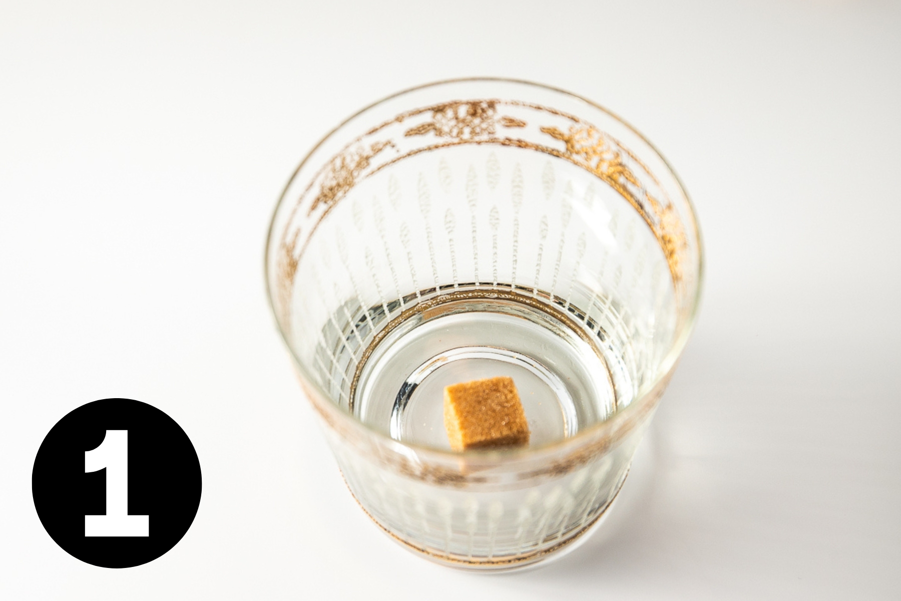 A cube of raw sugar in a glass.