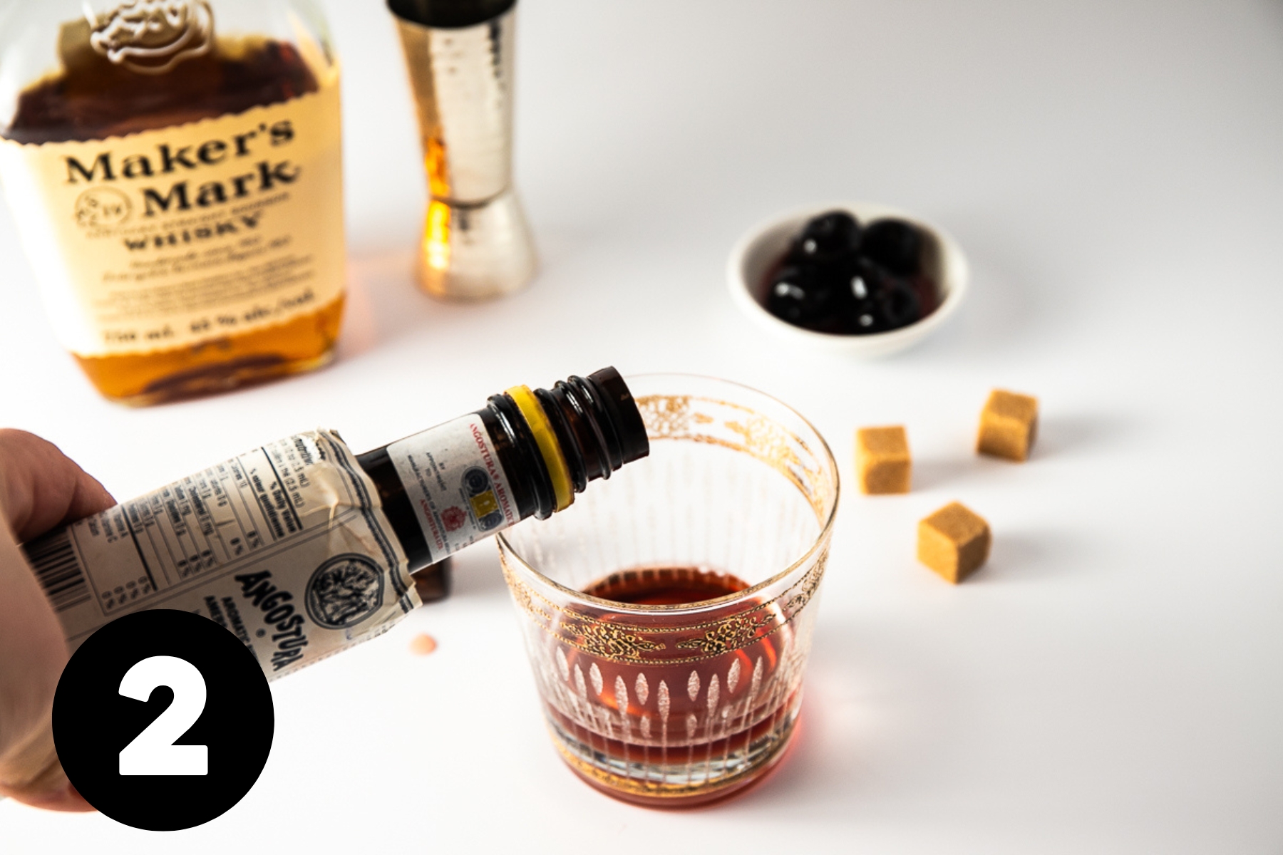 Bitters being added to the glass.