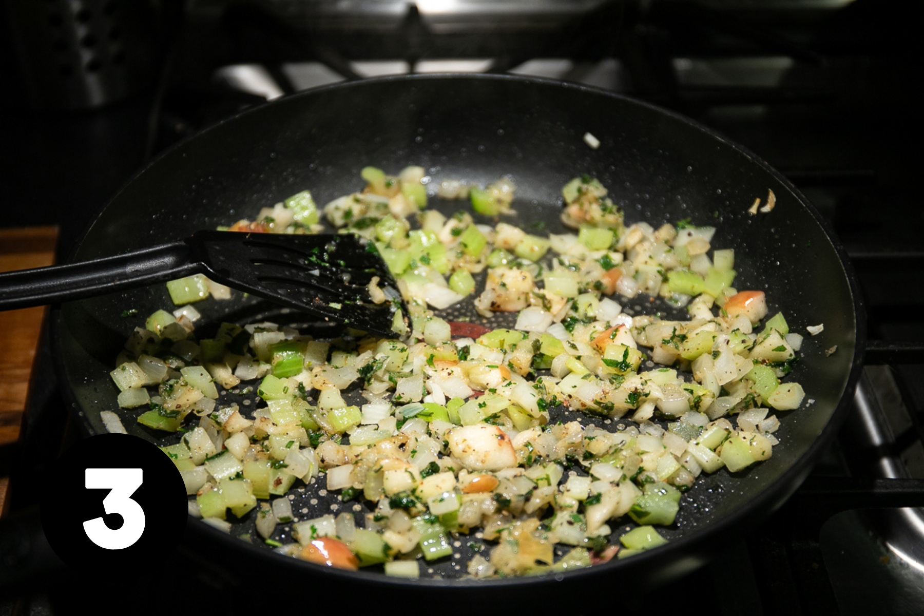 Frying pan of diced vegetables are softened.