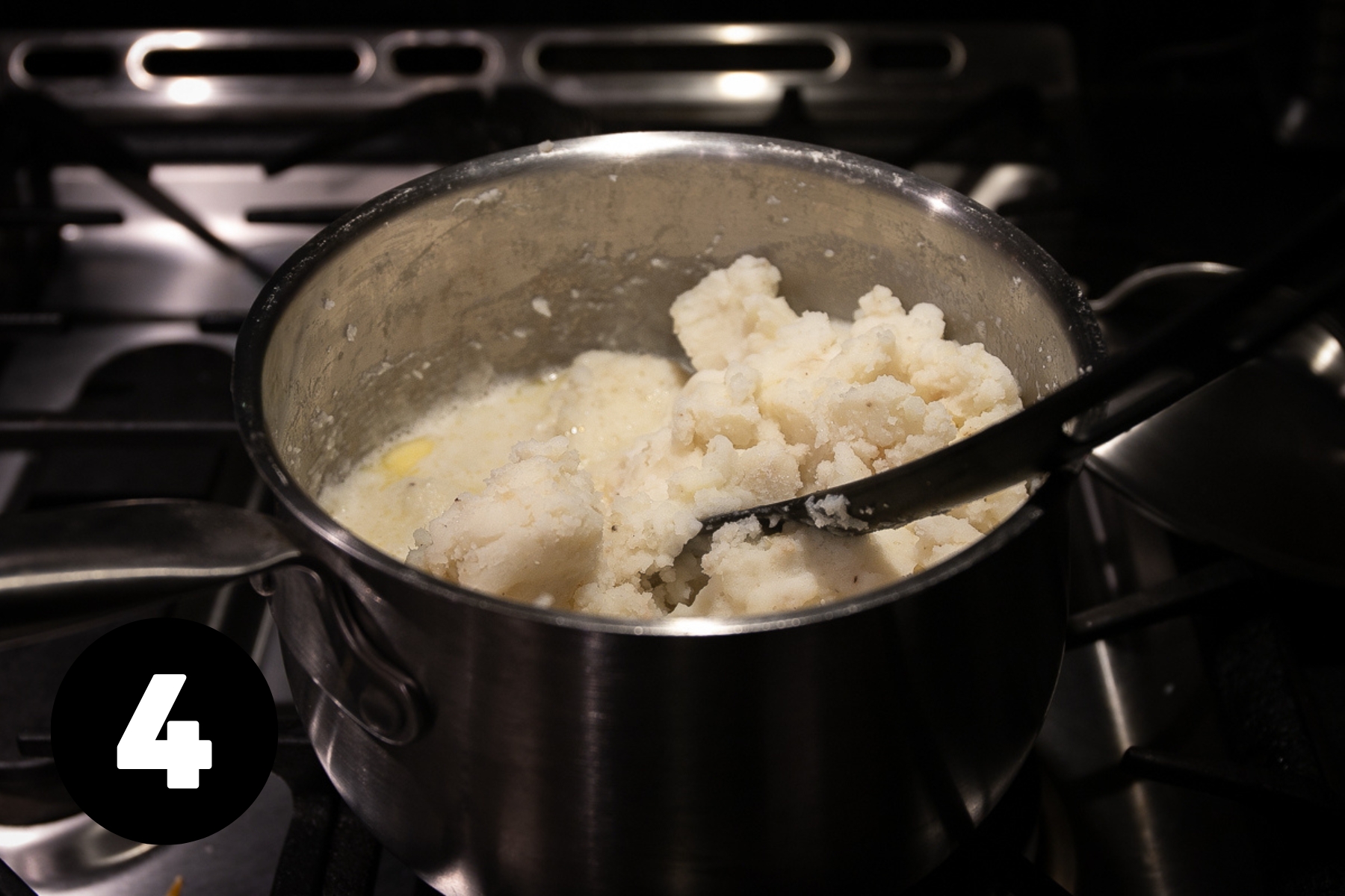 Potatoes are roughly mashed and have a pool of hot milk and half melted butter on one side.