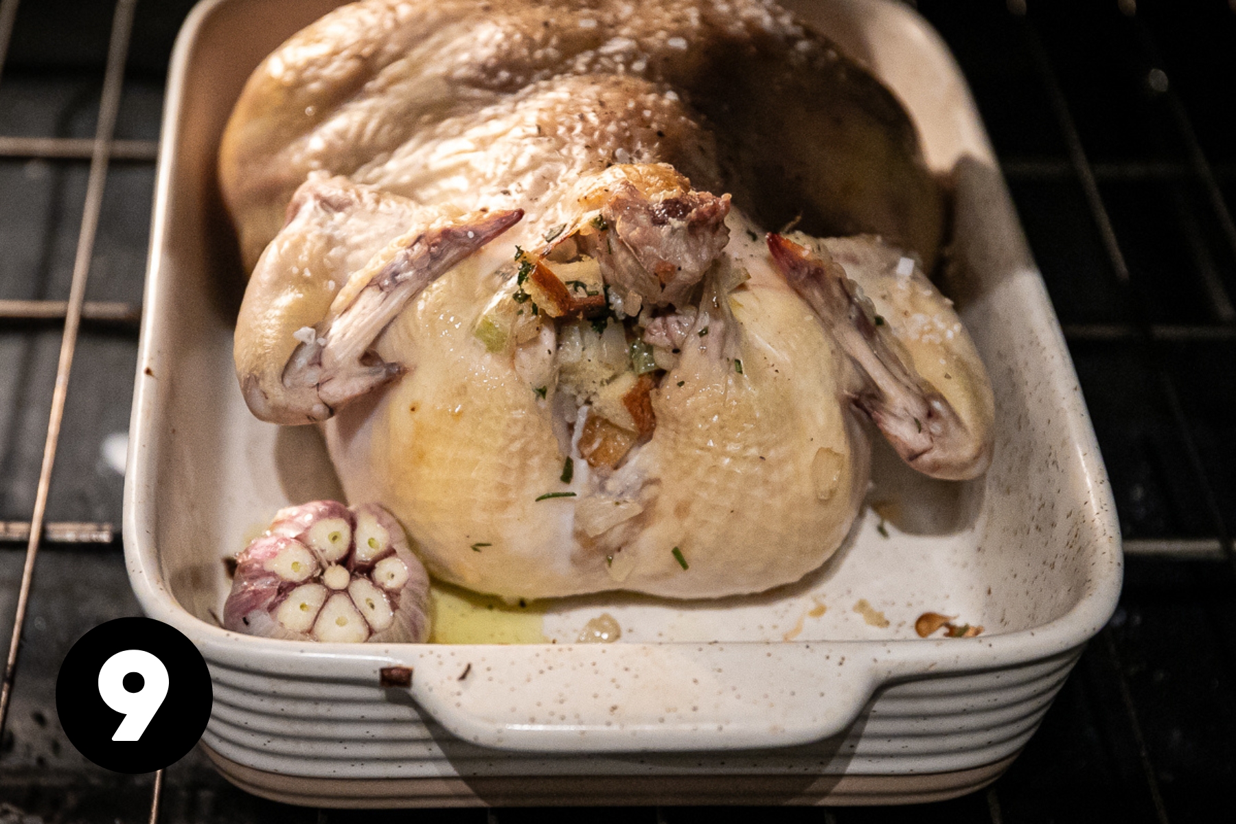 Roast chicken is partway cooked and light brown in the pan in the oven.