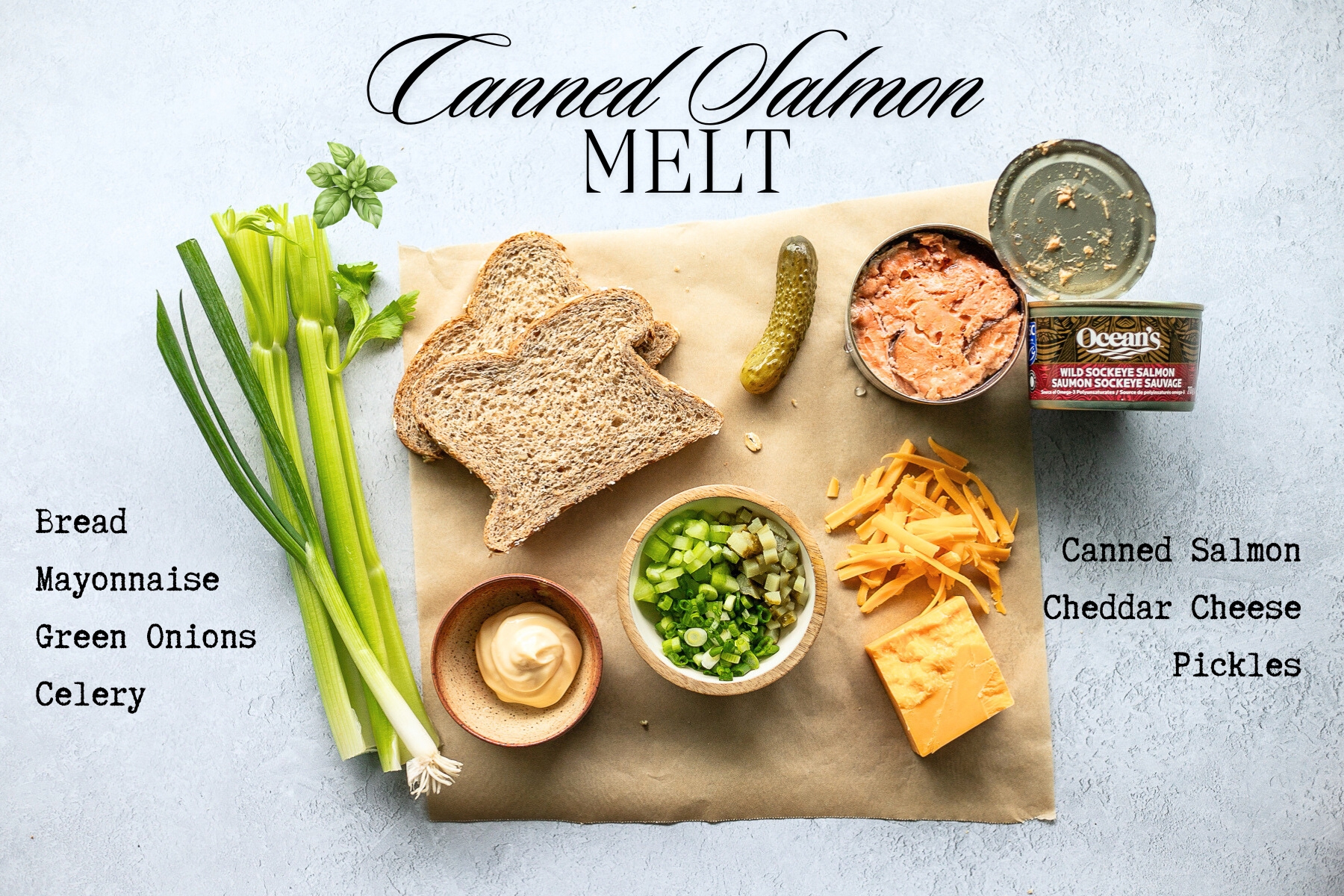 All the fresh ingredients for salmon melts on a square of parchment paper on a counter.