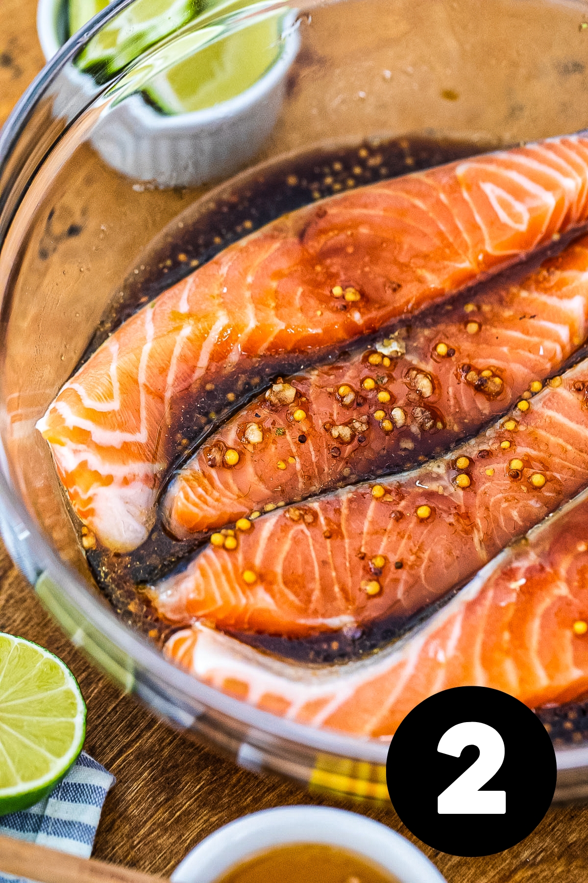 Slices of salmon in the glass bowl mixed with the marinade.