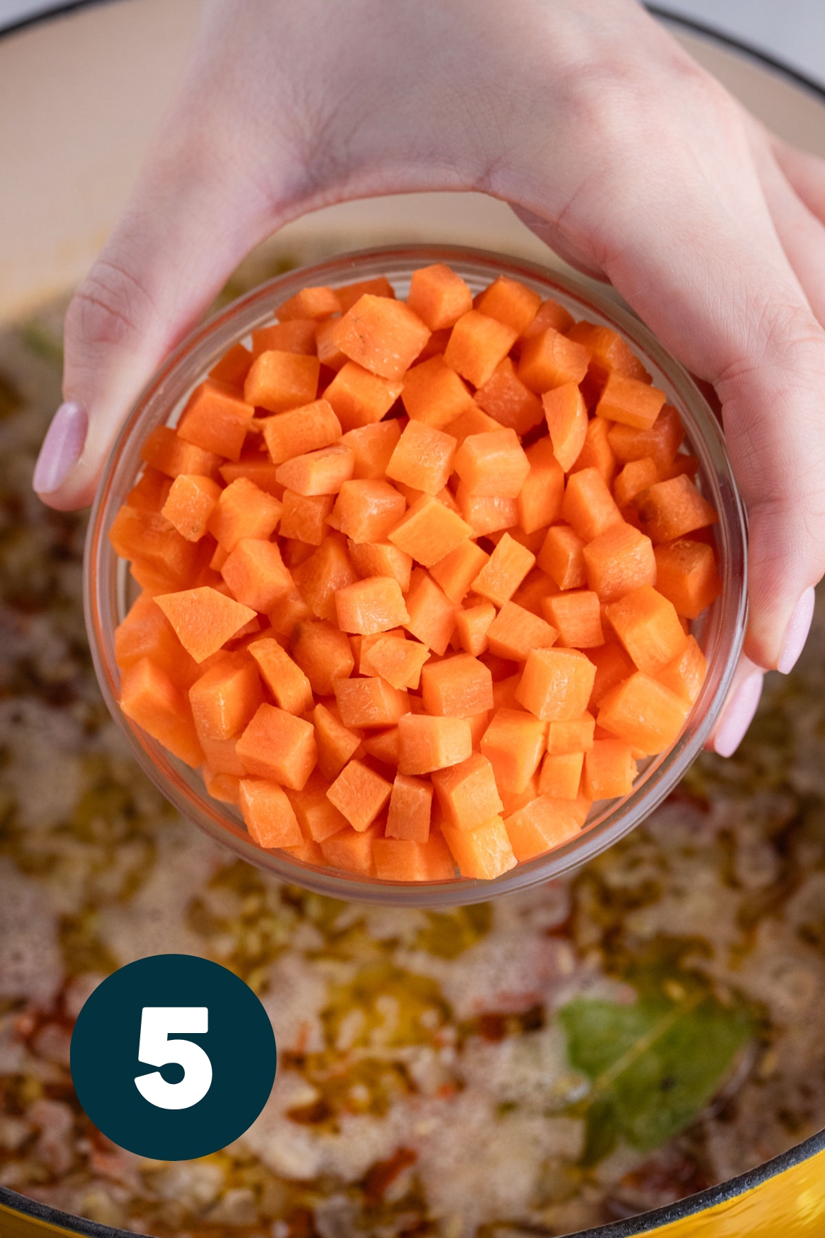 Diced carrots being added to the soup.