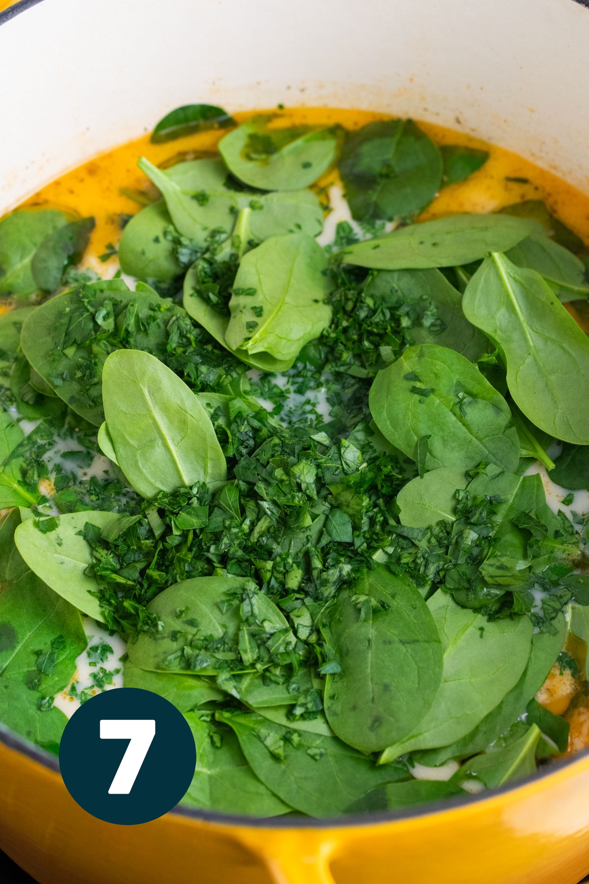 Fresh spinach leaves added to the soup pot.