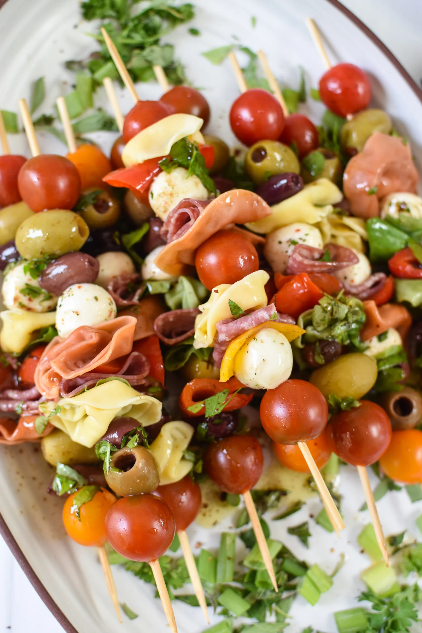 Antipasto skewers of olives, tomatoes, bologna, olives and herbs.
