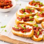 Platter of sundried tomato and basil topped crostini.