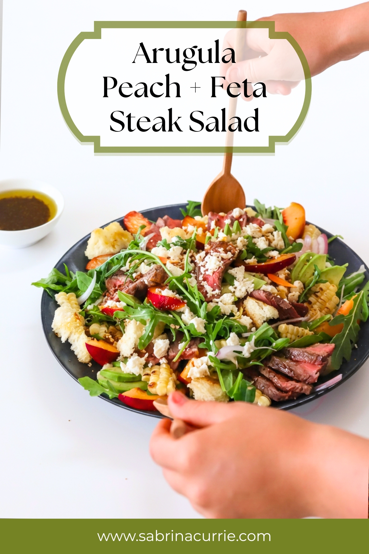 Hands tossing the salad with wooden salad tongs.