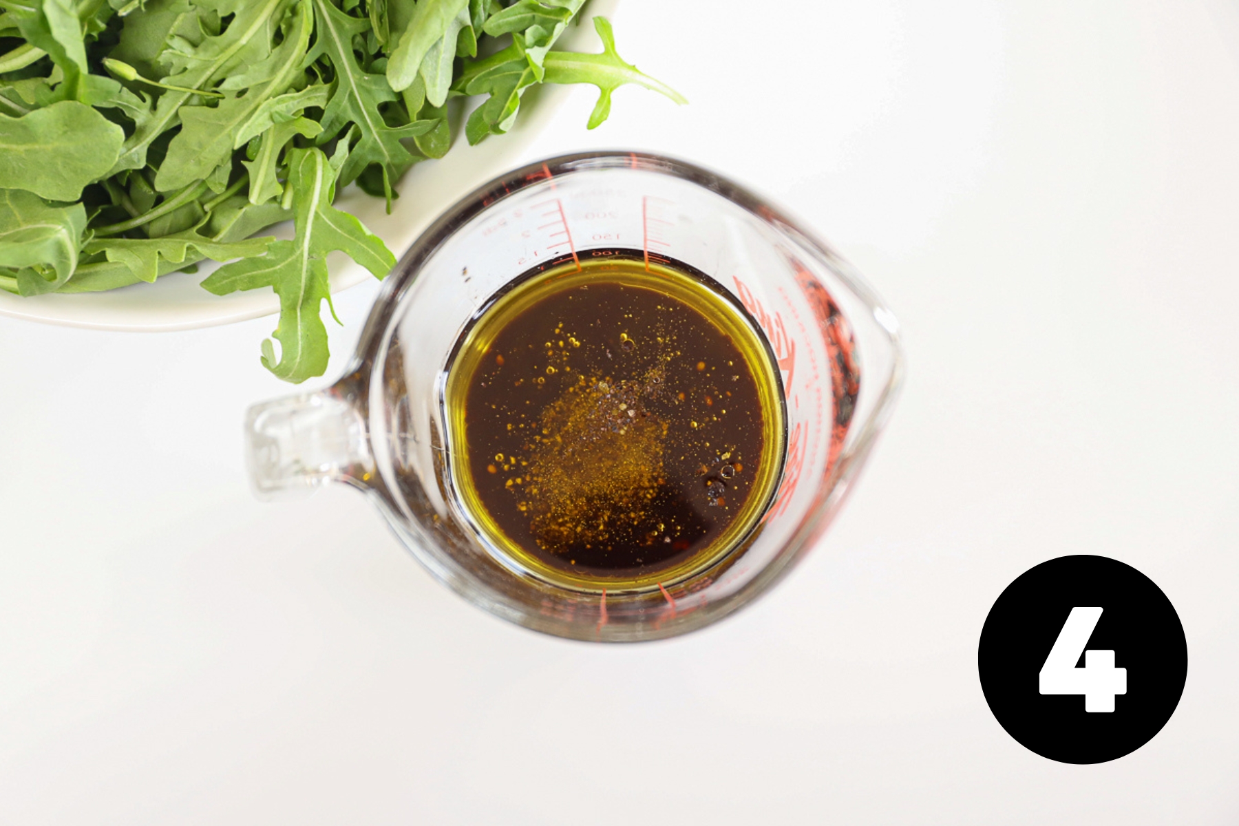 Salad dressing in a clear measuring cup.