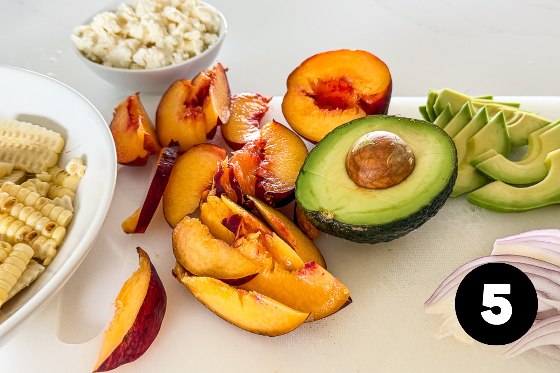 Sliced peaches, avocado and red onion.