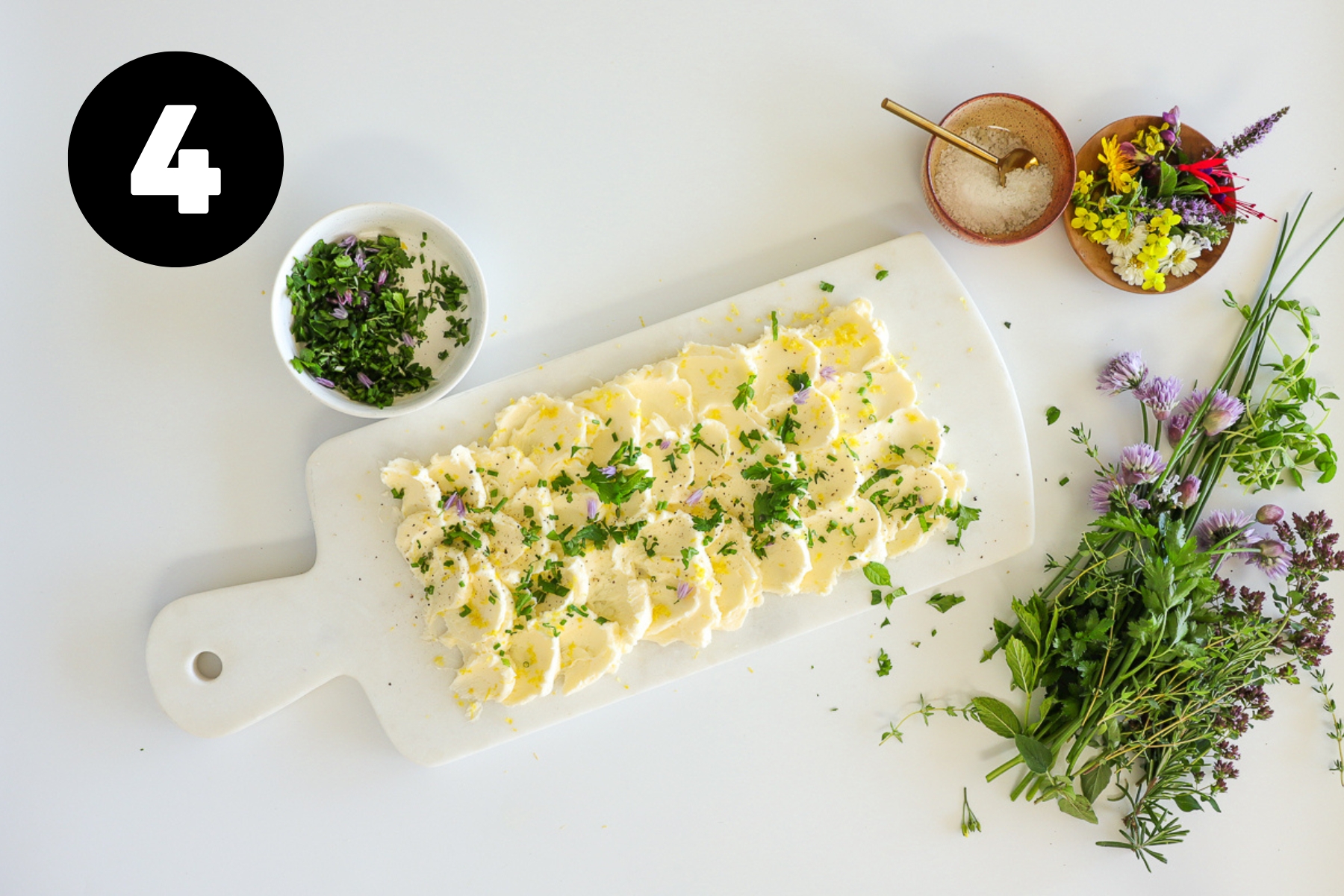 Chopped green herbs sprinkled lightly over the butter board.