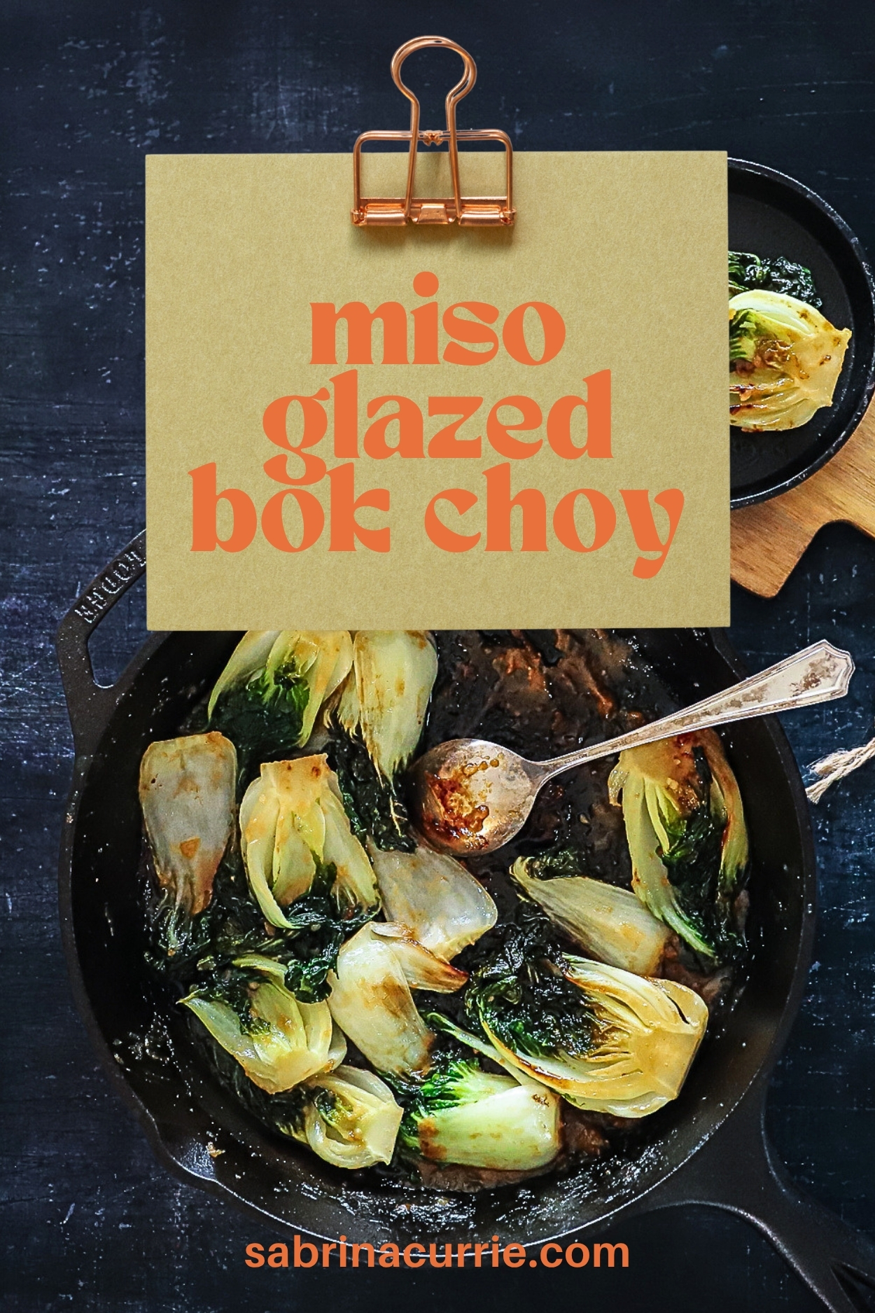 Miso glazed bok choy in a cast iron pan with the recipe title in a banner above.