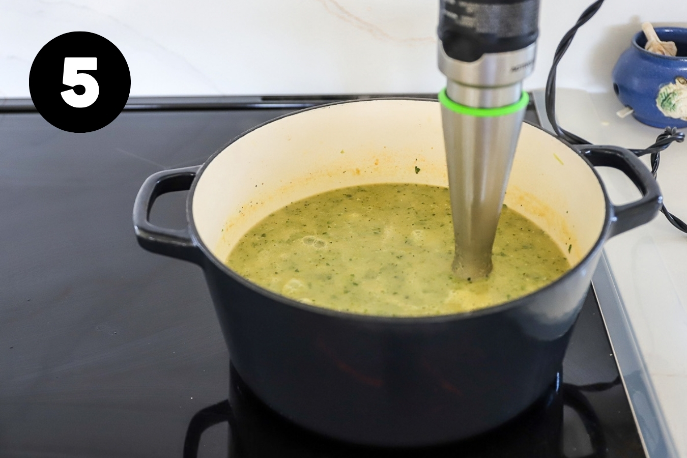 The stick blender in the soup and it is a creamy, homogenous mixture.