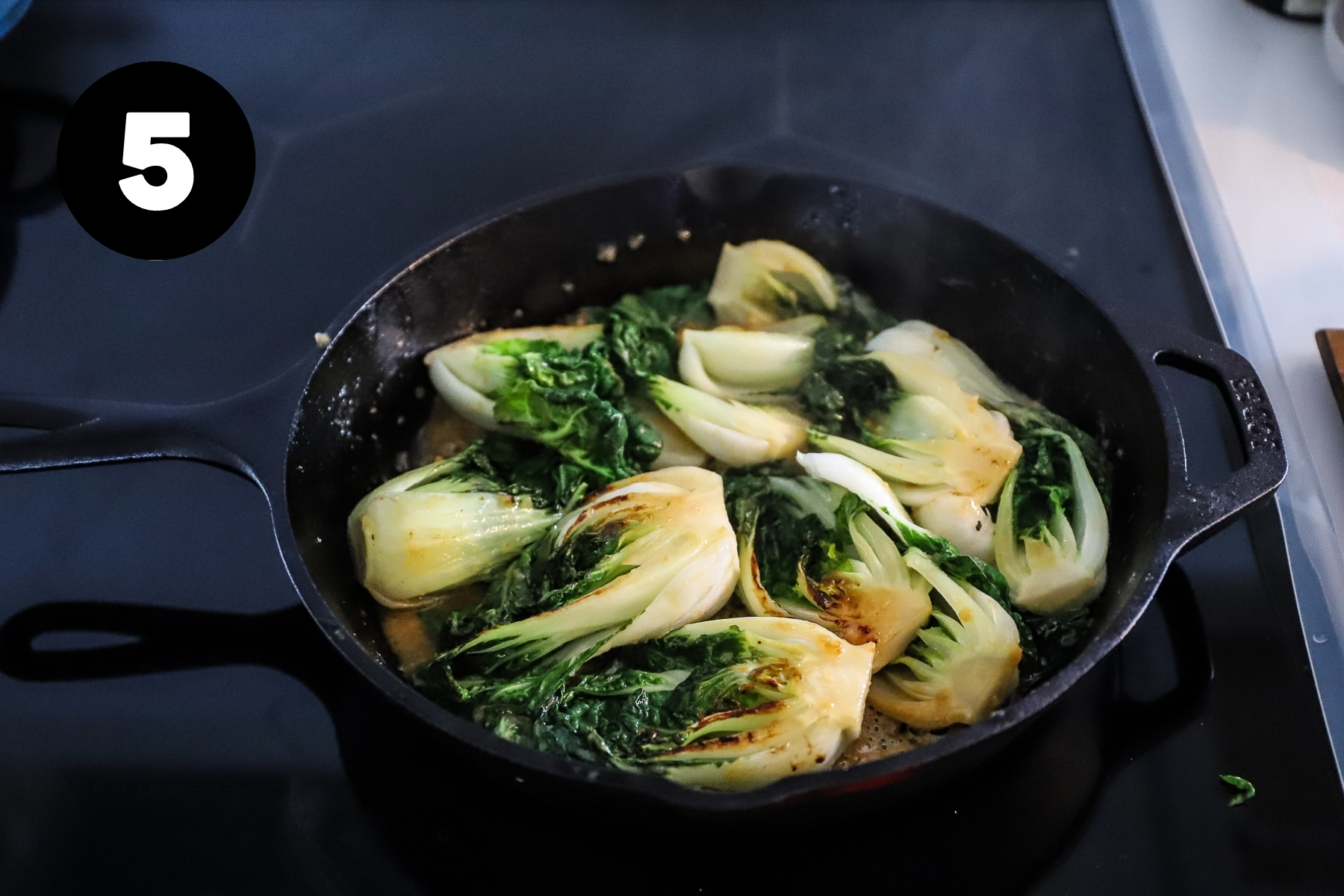 The bok choy have been flipped and show caramelization on the stalks.
